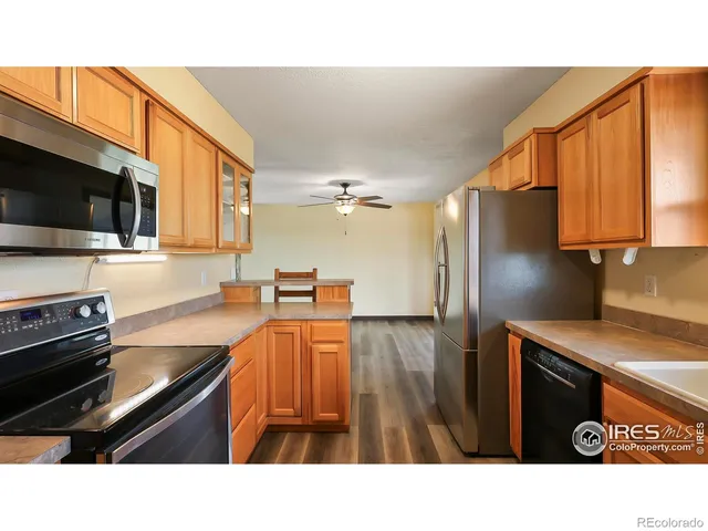 a kitchen with stainless steel appliances granite countertop a sink refrigerator stove and microwave