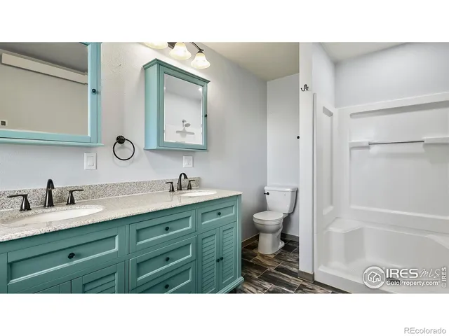 a bathroom with a sink double vanity granite and a toilet