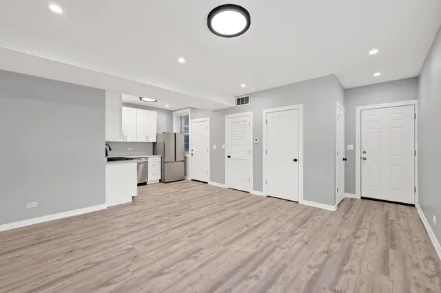 a view of empty room with wooden floor and window
