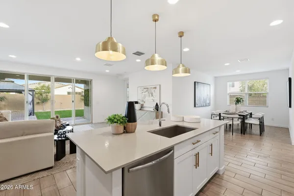 a kitchen with a sink a stove a refrigerator and white cabinets