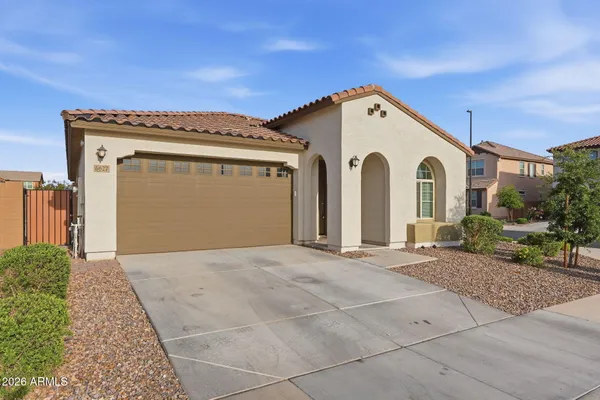 a view of a grey house with a garage