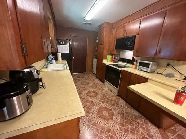 a kitchen with sink refrigerator and microwave