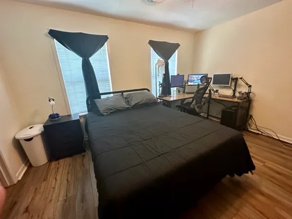 a bedroom with a bed and wooden floor