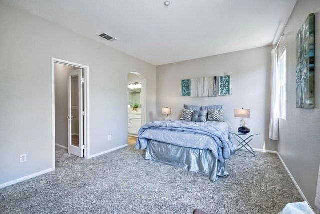 a spacious bedroom with a bed and a cabinets