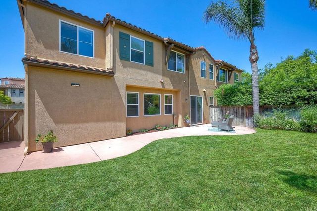 a front view of a house with a yard and potted plants