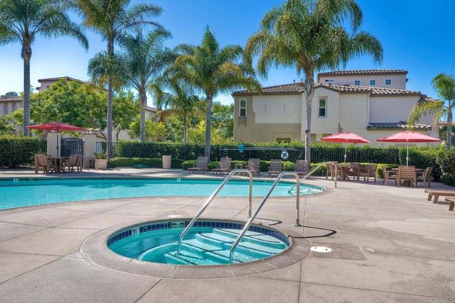 a swimming pool with outdoor seating yard and palm tree