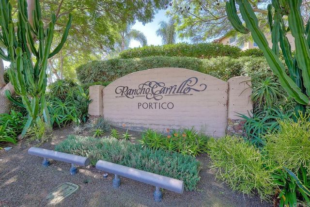 a sign that is sitting in front of a tree