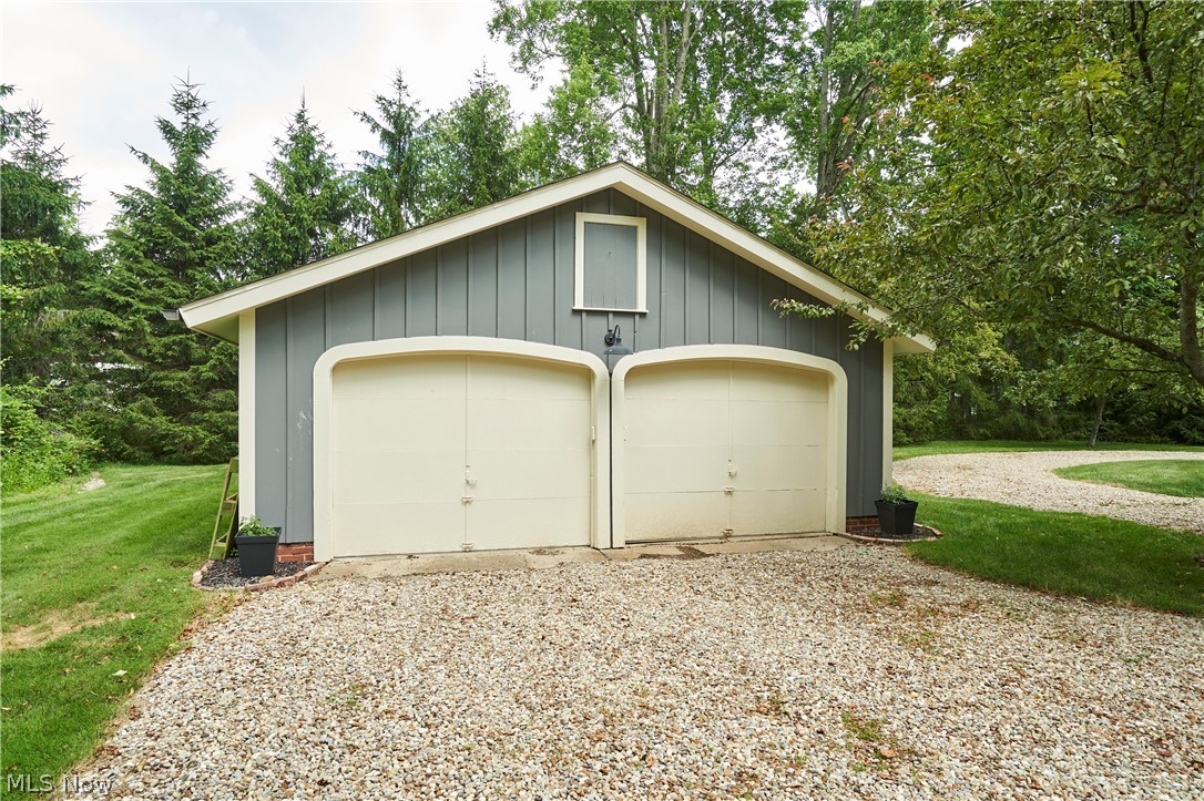 5046 Alger Road Richfield, OH 44286 - Photo 40 of 49 Two-car detached garage with a gravel driveway, gray vertical siding, and a white gable window