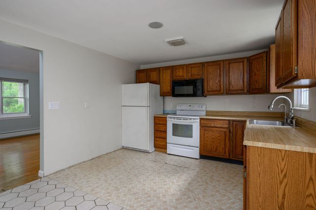 a kitchen with granite countertop a sink stove and refrigerator