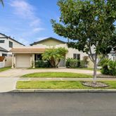 a front view of a house with a garden and trees