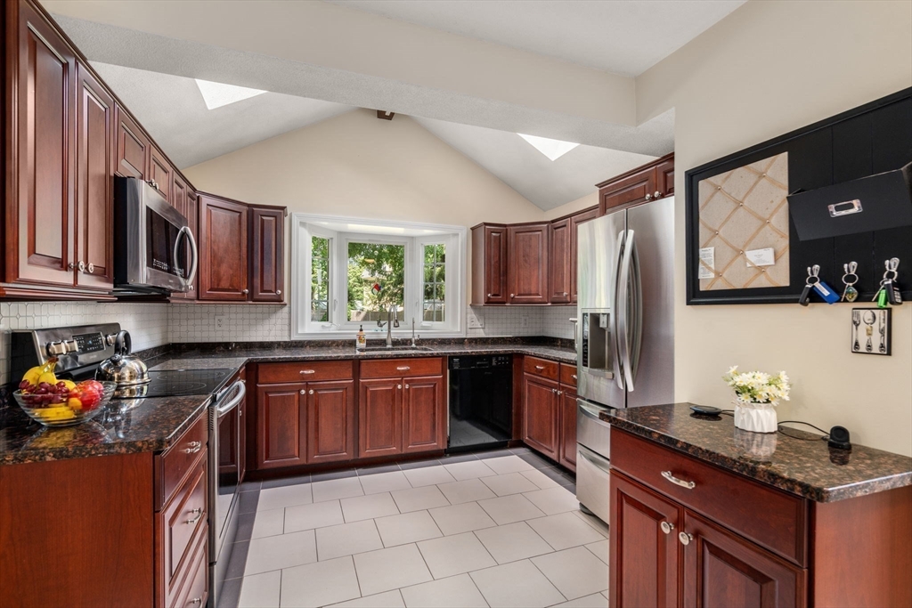 27 Prospect Avenue Arlington, MA 02476 - Photo 18 of 42 a kitchen with stainless steel appliances granite countertop a sink stove and refrigerator