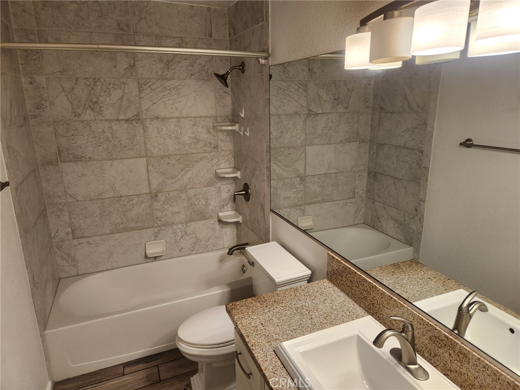 13237 Heritage Drive Victorville, CA 92392 - Photo 12 of 21 a bathroom with a granite countertop bathtub shower sink mirror and toilet