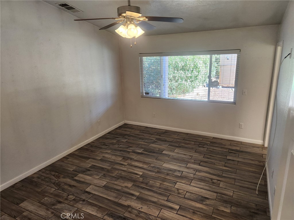 13237 Heritage Drive Victorville, CA 92392 - Photo 14 of 21 en empty room with wooden floor and window