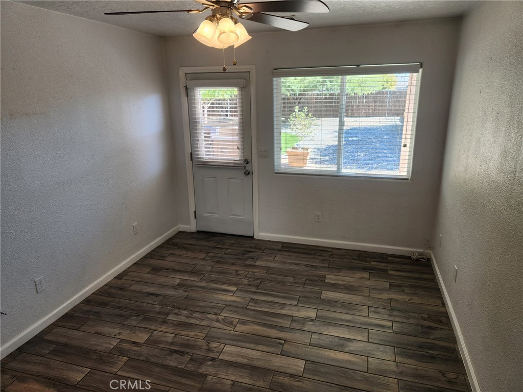 13237 Heritage Drive Victorville, CA 92392 - Photo 16 of 21 an empty room with wooden floor fan and windows