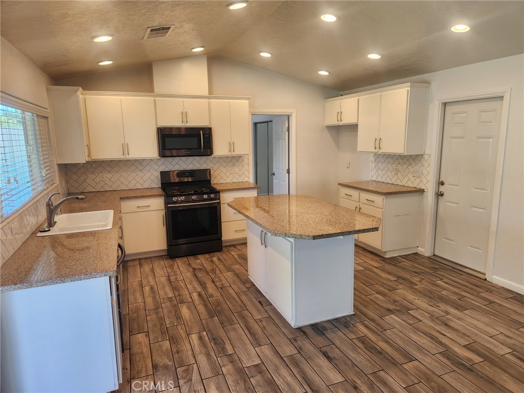 13237 Heritage Drive Victorville, CA 92392 - Photo 6 of 21 a kitchen with stainless steel appliances granite countertop a sink a stove and a refrigerator