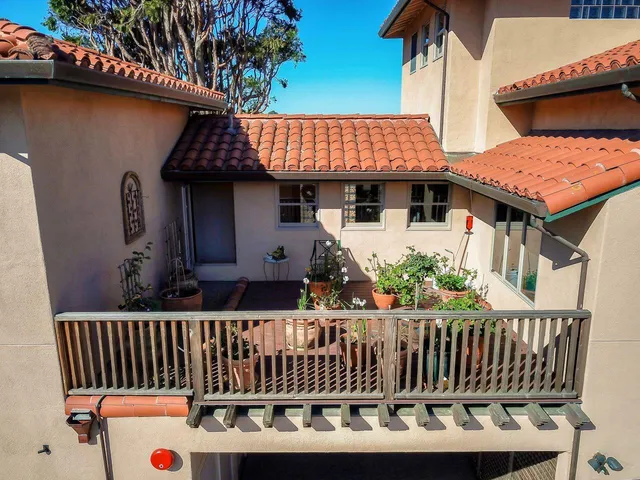 a view of a house with wooden deck and furniture