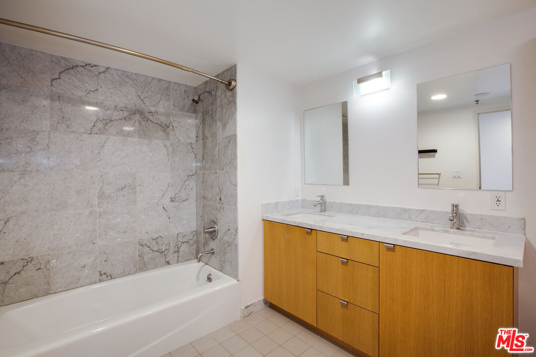 700 Main Street, Unit 5 Venice, CA 90291 - Photo 18 of 28 a bathroom with a granite countertop sink a mirror a bathtub and shower