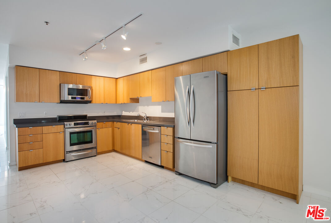 700 Main Street, Unit 5 Venice, CA 90291 - Photo 8 of 28 a kitchen with stainless steel appliances granite countertop a refrigerator a stove a sink and a microwave