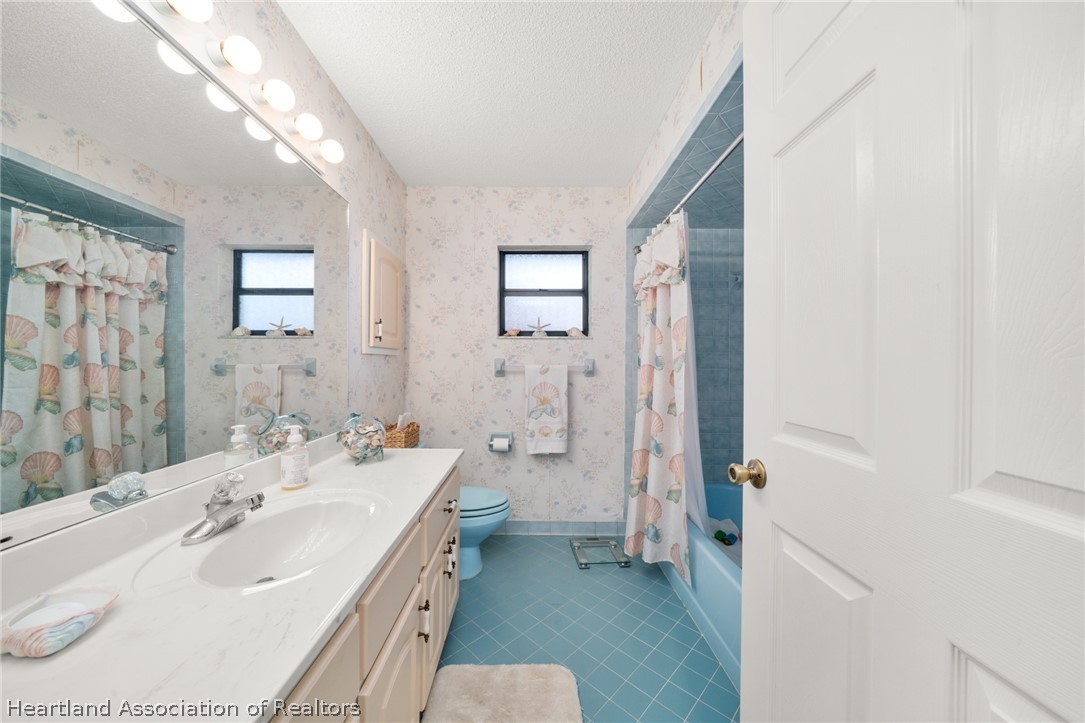 5802 Golden Road Sebring, FL 33875 - Photo 23 of 37 a spacious bathroom with a double vanity sink a toilet and a shower