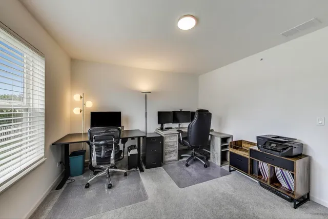 a view of a workspace with furniture and a window