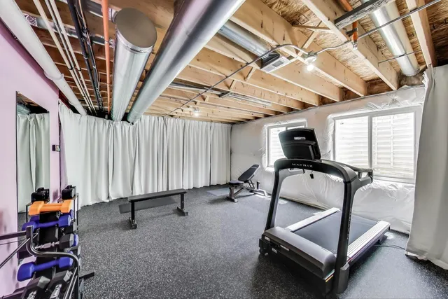 a view of gym equipment with wooden floor