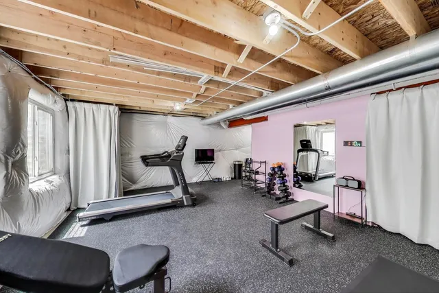 a living room with furniture gym equipment and a large window