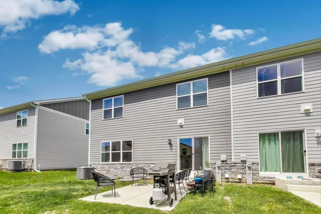 a backyard of a house with yard table and chairs