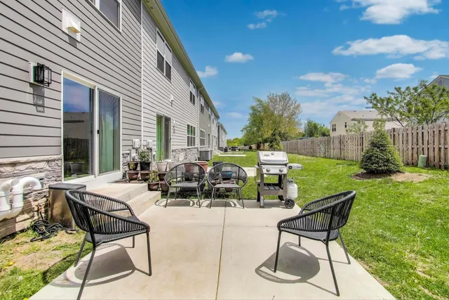 a view of a patio with table and chairs and potted plants and big trees