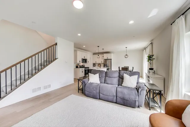 a living room with furniture and a view of kitchen