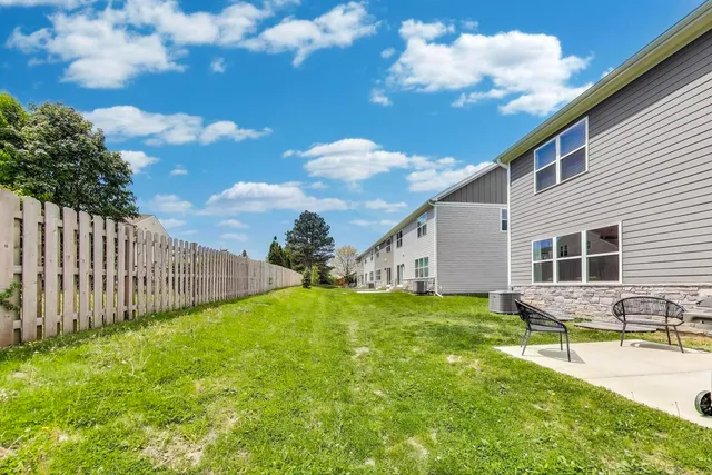 a backyard of a house with table and chairs