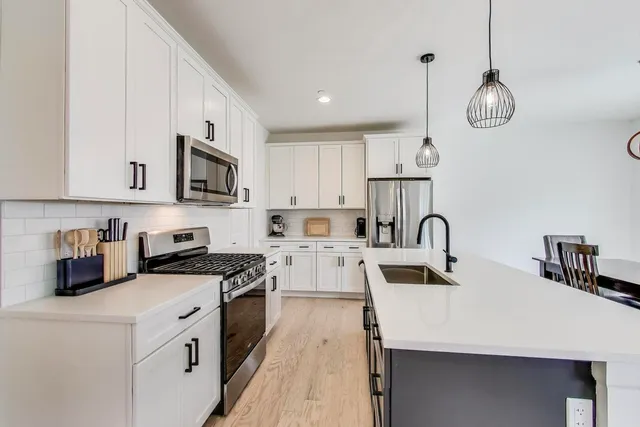 a kitchen with white cabinets stainless steel appliances and sink