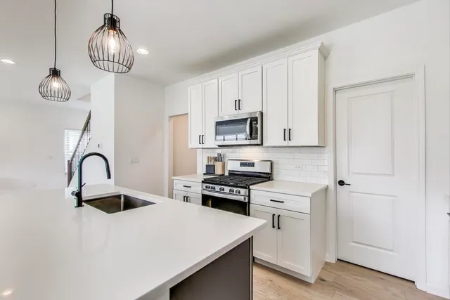 a kitchen with a sink stainless steel appliances and cabinets