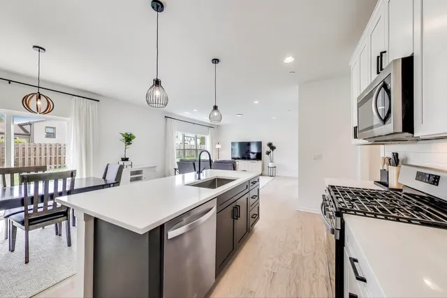 a kitchen with a sink a stove and chairs