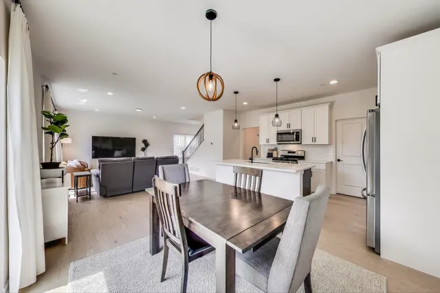 a kitchen with stainless steel appliances kitchen island a table and chairs in it