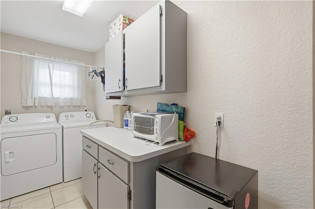 25378 Rupert Road Punta Gorda, FL 33983 - Photo 32 of 50 Dedicated laundry space featuring a window, built-in cabinetry, a countertop, an overhead light fixture, and tile flooring