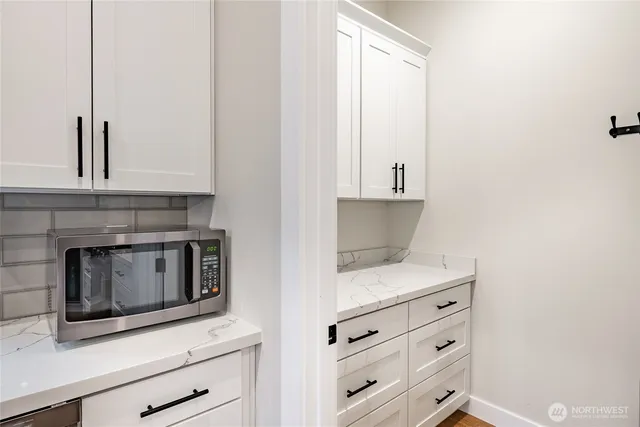 a kitchen with white cabinets and appliances