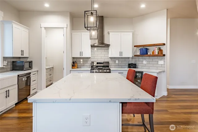 a kitchen with granite countertop a stove a sink and a refrigerator