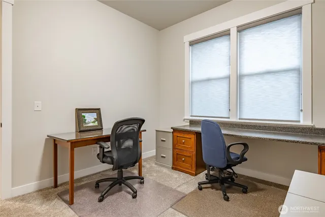 a view of a workspace with furniture and a window