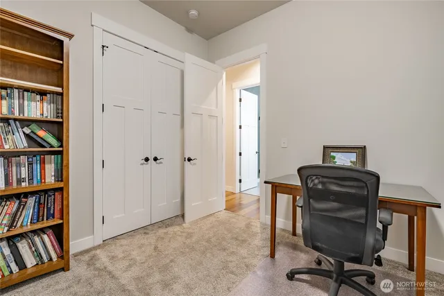 a view of a workspace with furniture and a book shelf