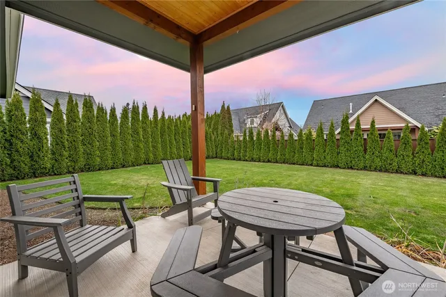 a view of a chairs and table in patio with a yard