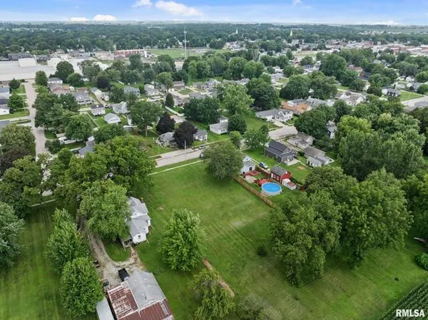 an aerial view of residential houses with outdoor space and trees