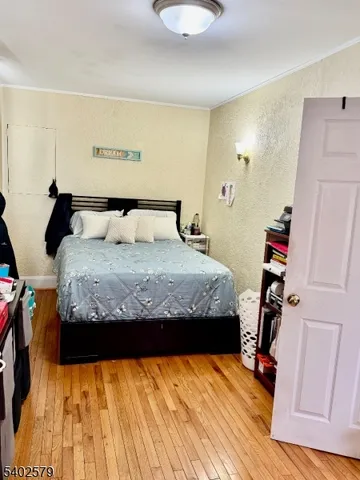 a bedroom with a bed and a wooden floor