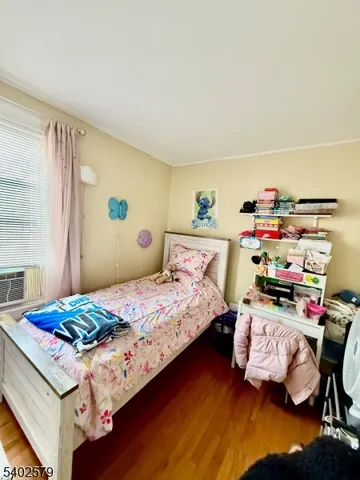 a bedroom with a bed and a wooden floor