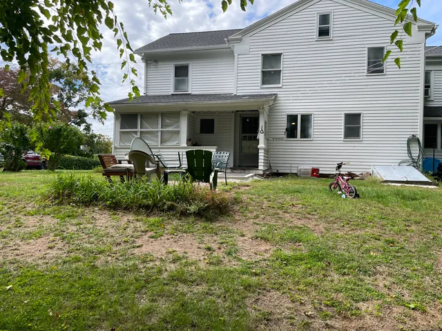 a view of an house with backyard space and sitting area