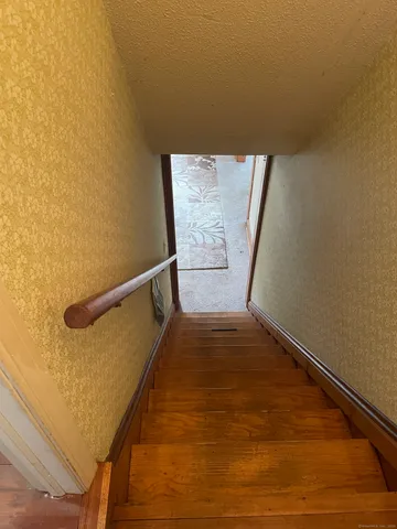 a view of staircase with railing and white walls