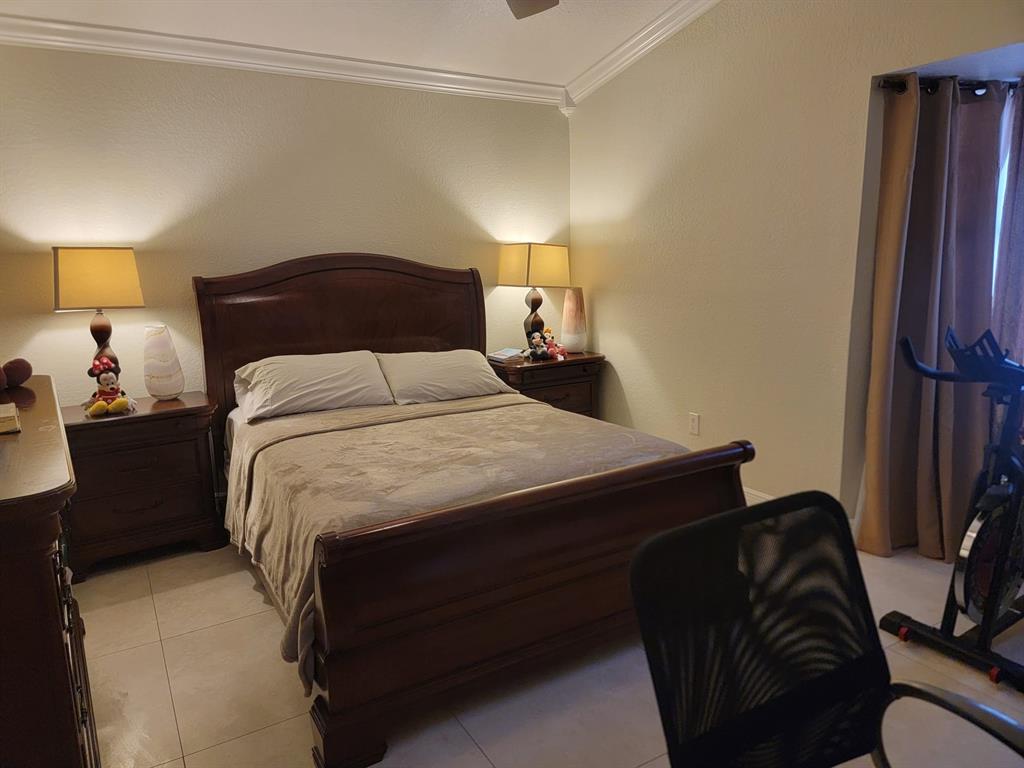 11821 Southwest 18th Street, Unit 223 Miami, FL 33175 - Photo 27 of 31 a bedroom with a bed and a lamp