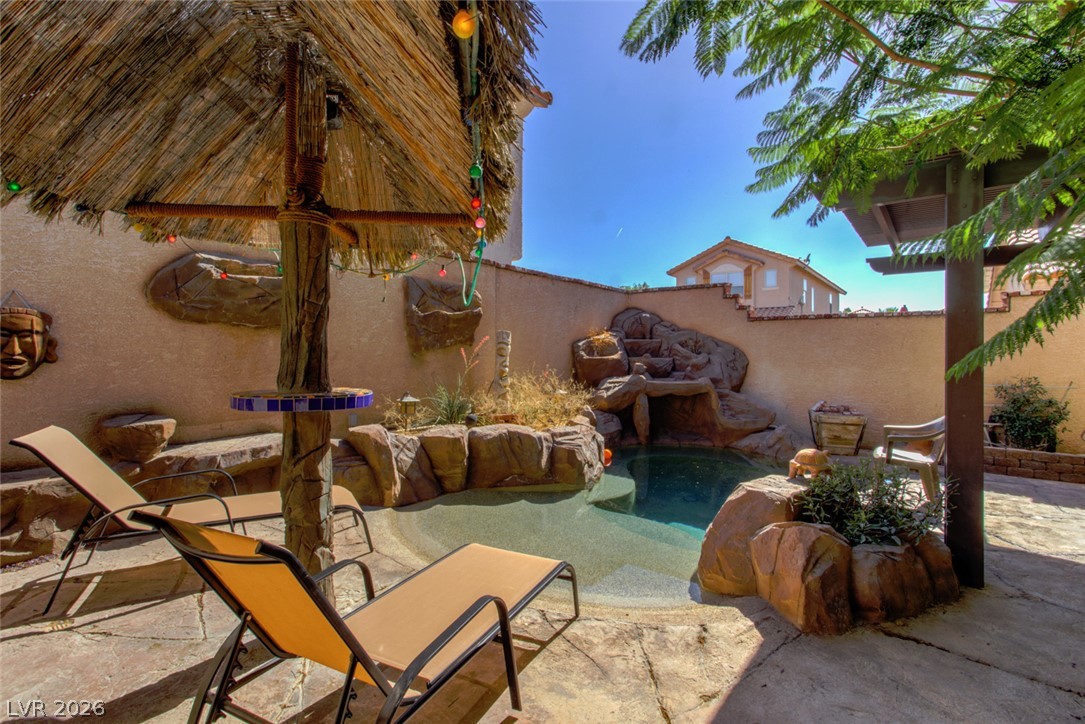 2023 Peacemaker Road Las Vegas, NV 89183 - Photo 23 of 24 An inviting backyard oasis showcases a custom rock-scaped pool complete with a gentle waterfall element.
