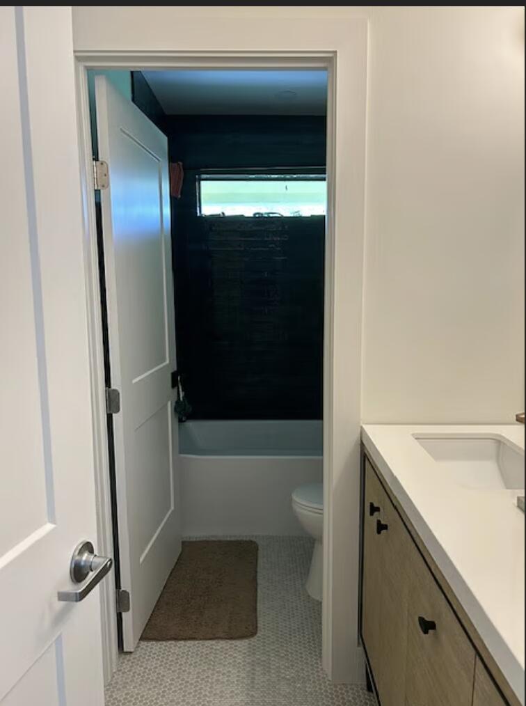 1822 Windsor Drive, Unit 1 Juno Ridge, FL 33408 - Photo 5 of 12 a bathroom with a tub a sink and a large mirror