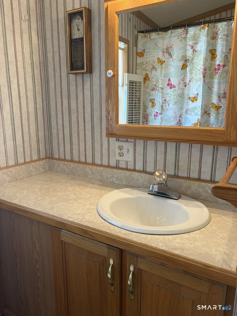 62 Fort Hill Road Groton, CT 06340 - Photo 11 of 11 a bathroom with a sink and a mirror