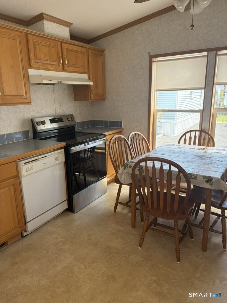 62 Fort Hill Road Groton, CT 06340 - Photo 4 of 11 a kitchen with stainless steel appliances granite countertop a sink a stove a dining table and chairs with wooden floor